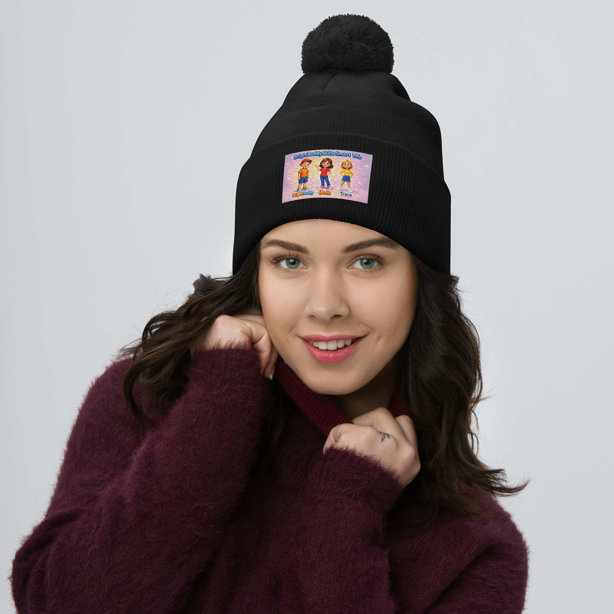 BrightBuddySkills Smart Trio pom-pom knit beanie, black, front view — product mockup